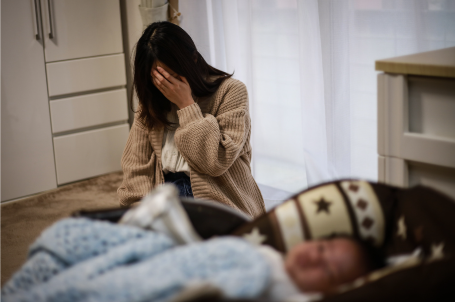 赤ちゃんが眠ったあと、疲れ切っているお母さん