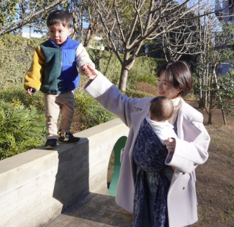 下の子を抱っこしながら上の子と手をつないで歩く様子